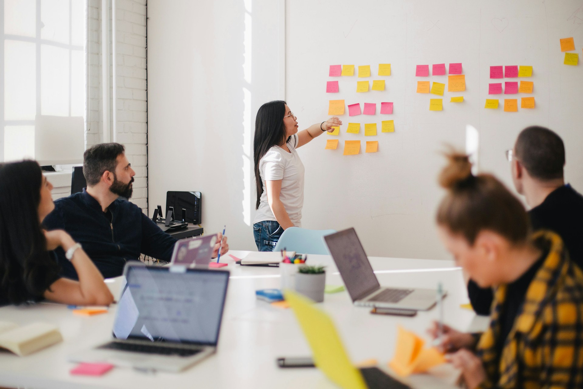 Groupe de travail devant un tableau avec des post'its